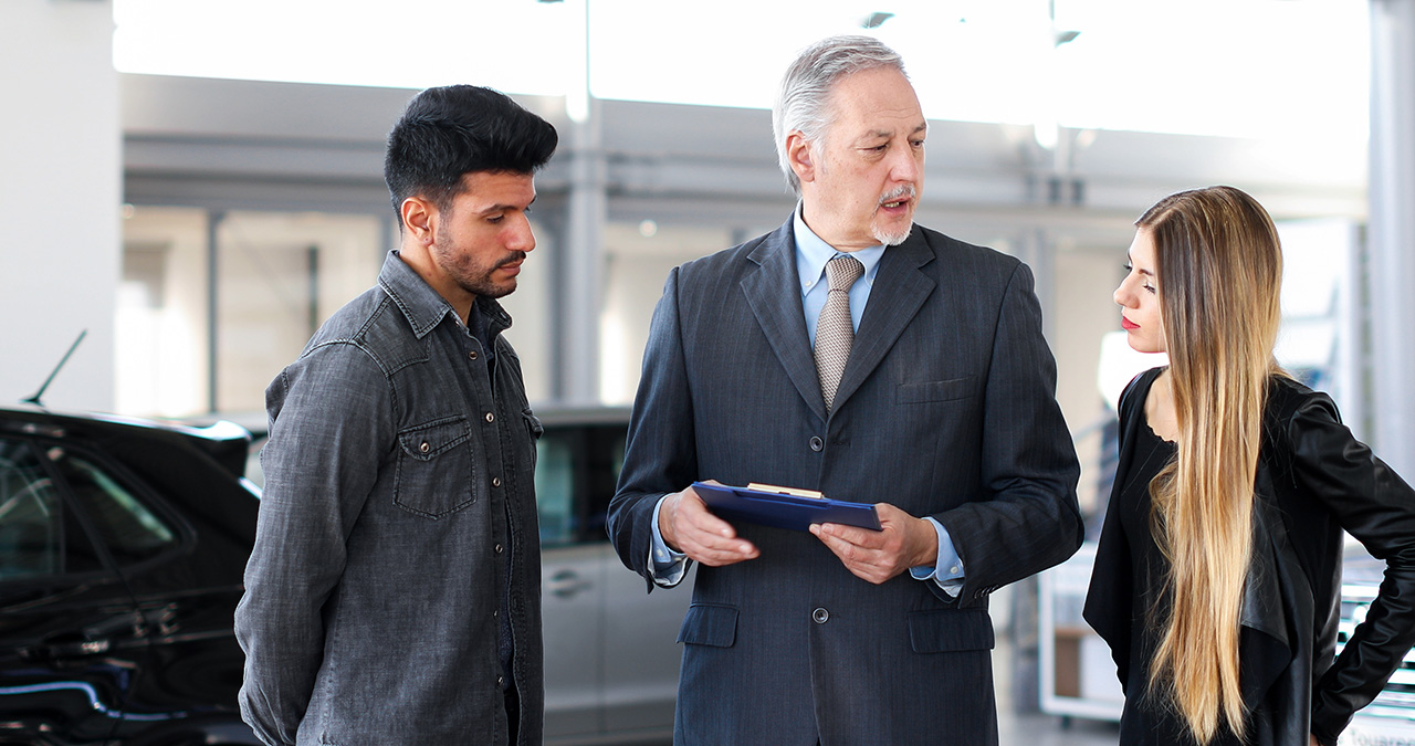 Couple discussing refinancing with a Mazda financing team member