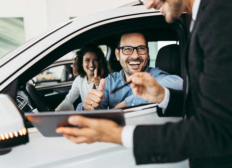 salesman with tablet and family in car Middletown Mazda in Middletown NY